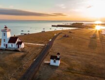 An aerial photo of the Woods Island Lighthouse on PEI, during a winter sunset.