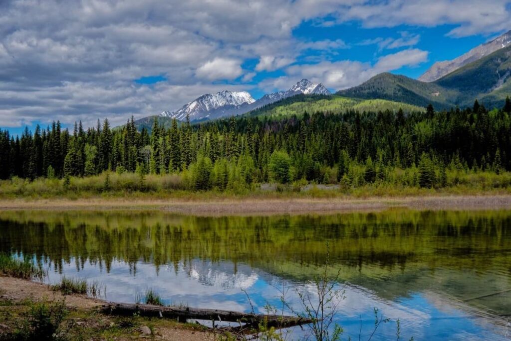 Colorful reflections of the Rocky Mountains are seen in Dog Lake in Kootenay National Park