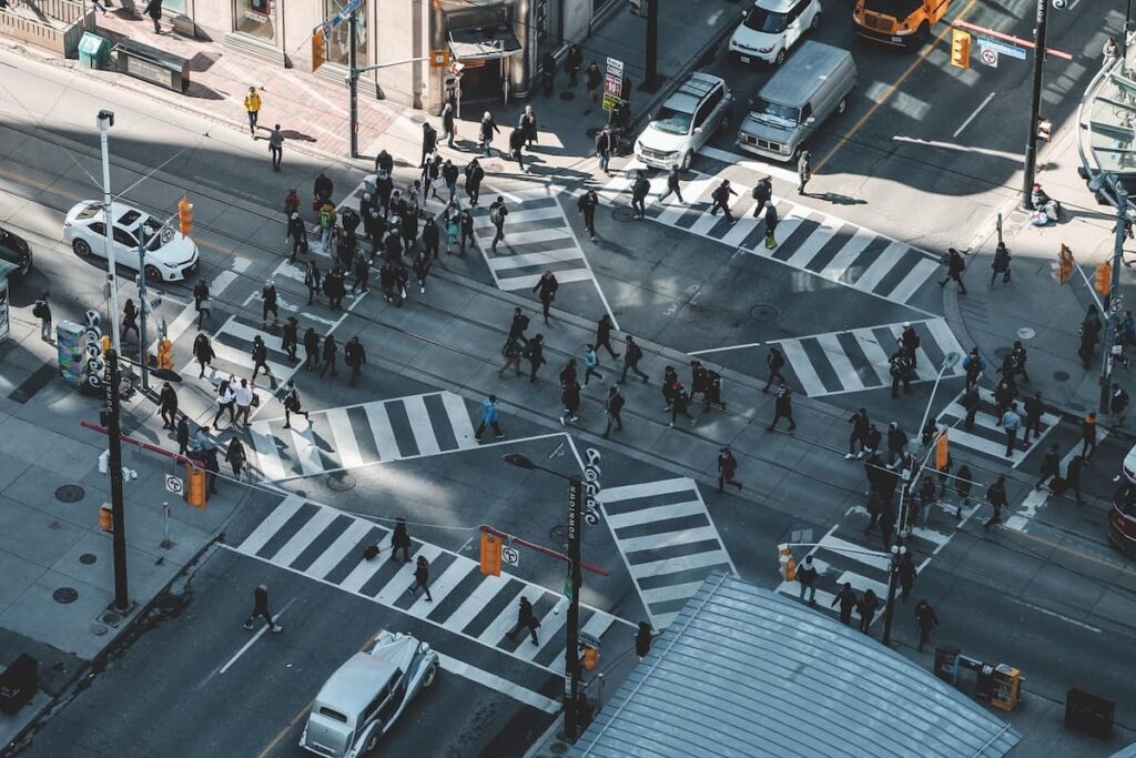 A group of people at a busy intersection in Canada.