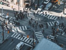 A group of people at a busy intersection in Canada.