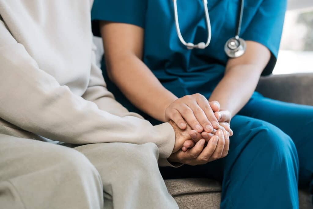 A nurse comforts an elderly patient