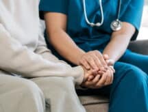 A nurse comforts an elderly patient