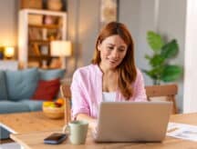 A woman sits at her laptop checking the next CRS score.