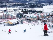 A group of skiers going downhill at mount tremblant.