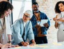 Team of workers in an office, using sticky notes.