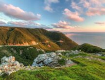 The winding Cabot Trail road seen from high above on the Skyline Trail at sunset in Cape Breton Highlands National Park, Nova Scotia.