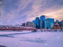 A scenic view of snow falling down over the Peace bridge and Bow river in Calgary, Alberta.