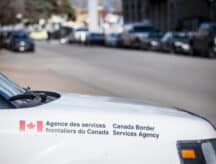 A CBSA patroller with an open street in the background.