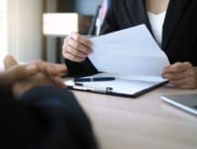 A person receives a job offer letter in person.