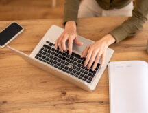 A person types their work experience into their laptop.