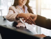 A young woman shakes hands with an employer