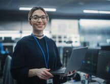 Smiling woman holds a laptop