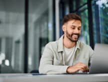An Indian man types on a computer