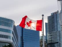 The Canadian flag surrounded by buildings