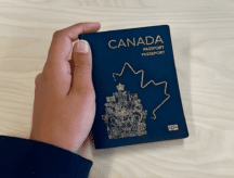 Hand holding a Canadian passport.