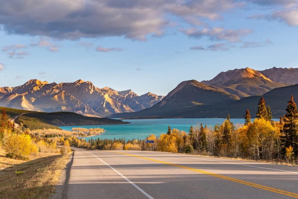 A view of a mountain, lake, and road in Alberta.