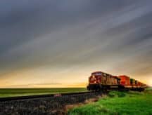 A train speeds through rural Manitoba on a sunsetting summer's day.