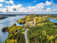 Aerial shot of small town coast in Newfoundland and Labrador on a sunny day, with the ocean visible in the back.