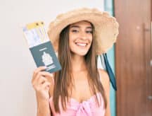 A young woman holds up her Canadian passport