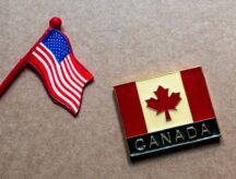 A Canadian and American pin lying side by side