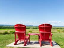 Red Adirondack chairs at Grand-Pré National Historic Site