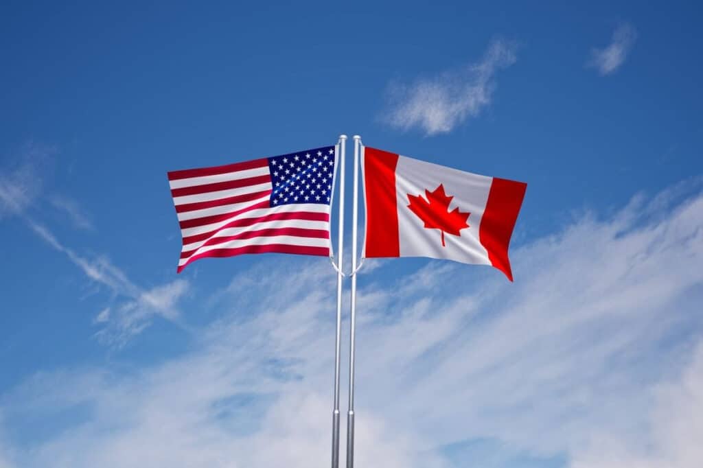 The Canadian and American flags flying beside each other