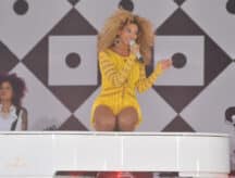 Beyoncé sitting atop a piano, singing, in Central Park, Manhattan, NYC, for the Good Morning America's Summer Concert Series.