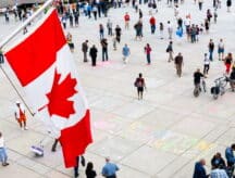 A picture of a populated square in Canada, with people walking in all directions.