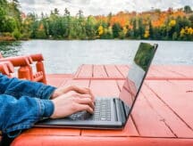 A person sitting on their laptop outside looking for a Canadian ancestor