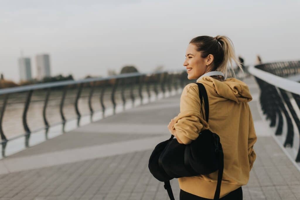 A woman looks out across a bridge on an overcast day.