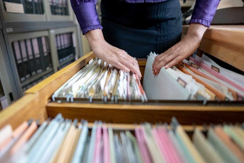 The hand of a woman sorting important documents