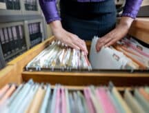The hand of a woman sorting important documents