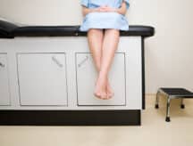 A person sits waiting in the doctor's office as they await treatment.