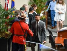 A man shaking hands with an RCMP officer at a Canadian citizenship ceremony in Hamilton, Ontario.