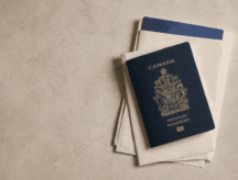 A picture of a Canadian passport sitting atop a desk.