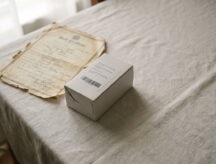 A birth certificate sits next to a DNA testing kit