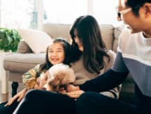 Young Asian family and pet dog playing at home