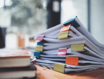 A picture of a stack of organized files sitting on a desk.