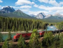 A red cargo train passing through Morant's curve in Bow Valley, Banff National Park, Alberta, Canada.