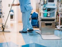 A worker cleaning the floors in an operation room in a hospital.