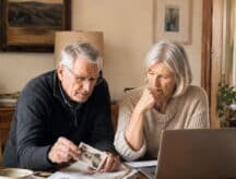 An elderly couple look upon their family records in a bid to determine their Canadian ancestry.