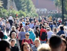 Large quantity of people all walking in different directions.
