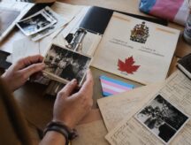 A woman looks over old photos as she mulls over a succesful citizenship application for her daughter.