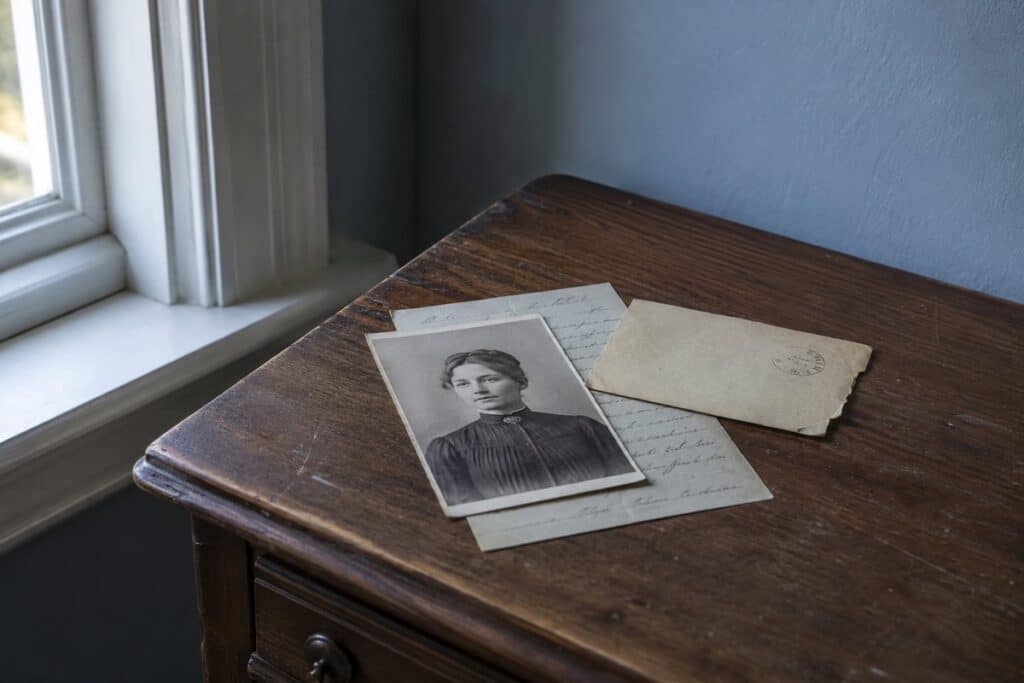 A picture of a Quebec ancestor with a baptismal record placed below them.