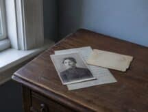 A picture of a Quebec ancestor with a baptismal record placed below them.