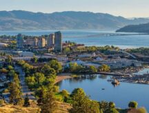 The Kelowna British Columbia skyline and Okanagan Lake with the R W Bennett Bridge in the background, from Knox Mountain at sunset.