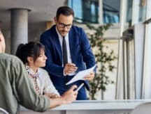 A business man showing a businesswoman some documents, serious faces.