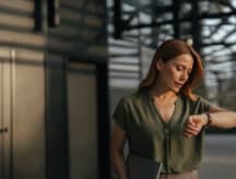 Woman with serious face checking her wristwatch.